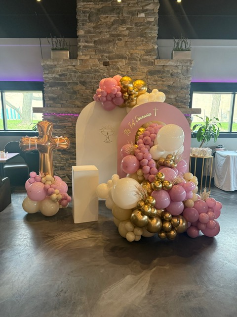 Pink, cream, and gold balloon backdrop with cross balloon
